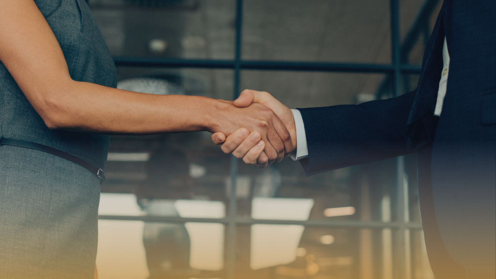 Handshake across a glass table in an office